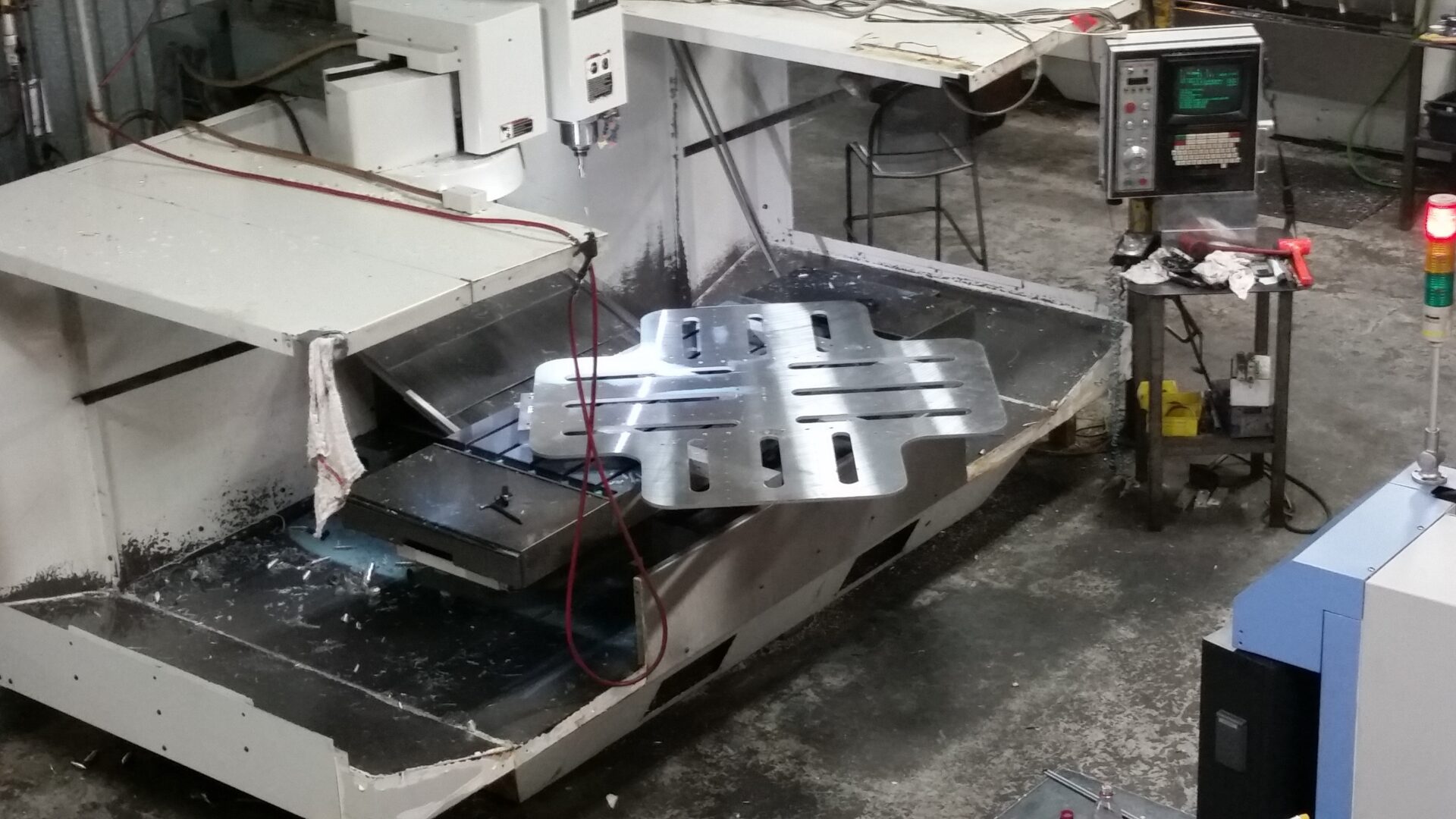 CNC machining center with a star-shaped metal plate on the table
