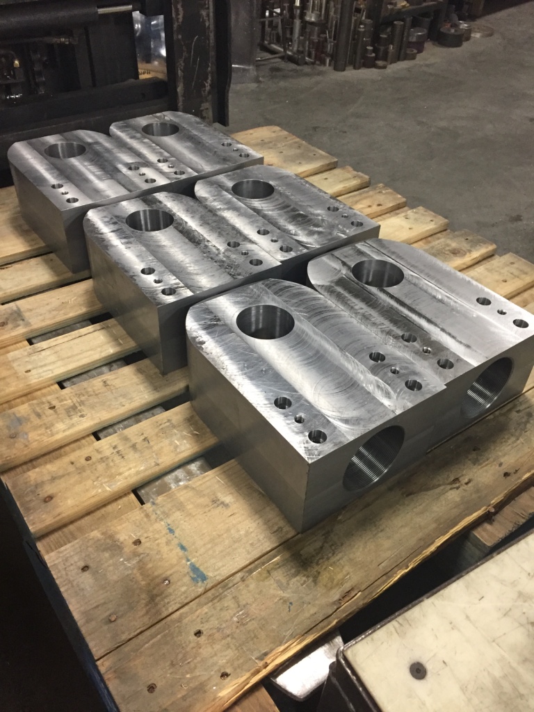 Finished machined steel blocks stacked on a wooden pallet