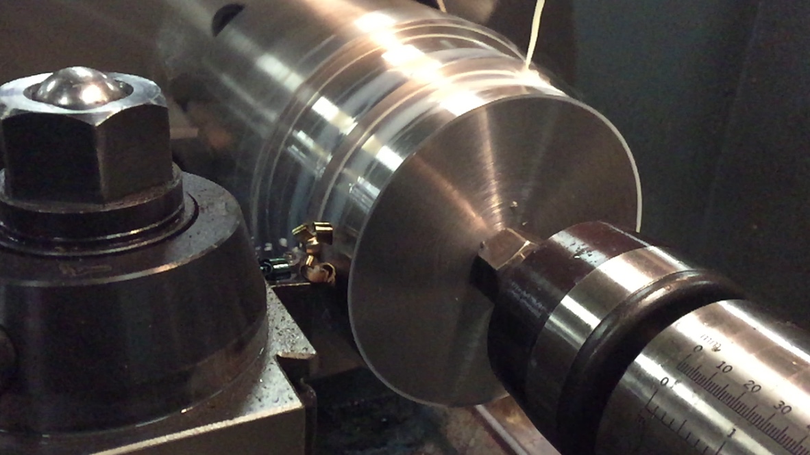 Lathe turning a cylindrical metal workpiece